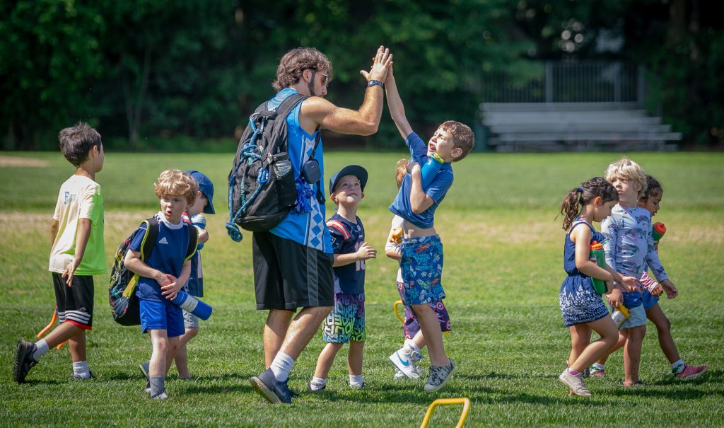 Fessenden Summer Camps staff high fiving kids